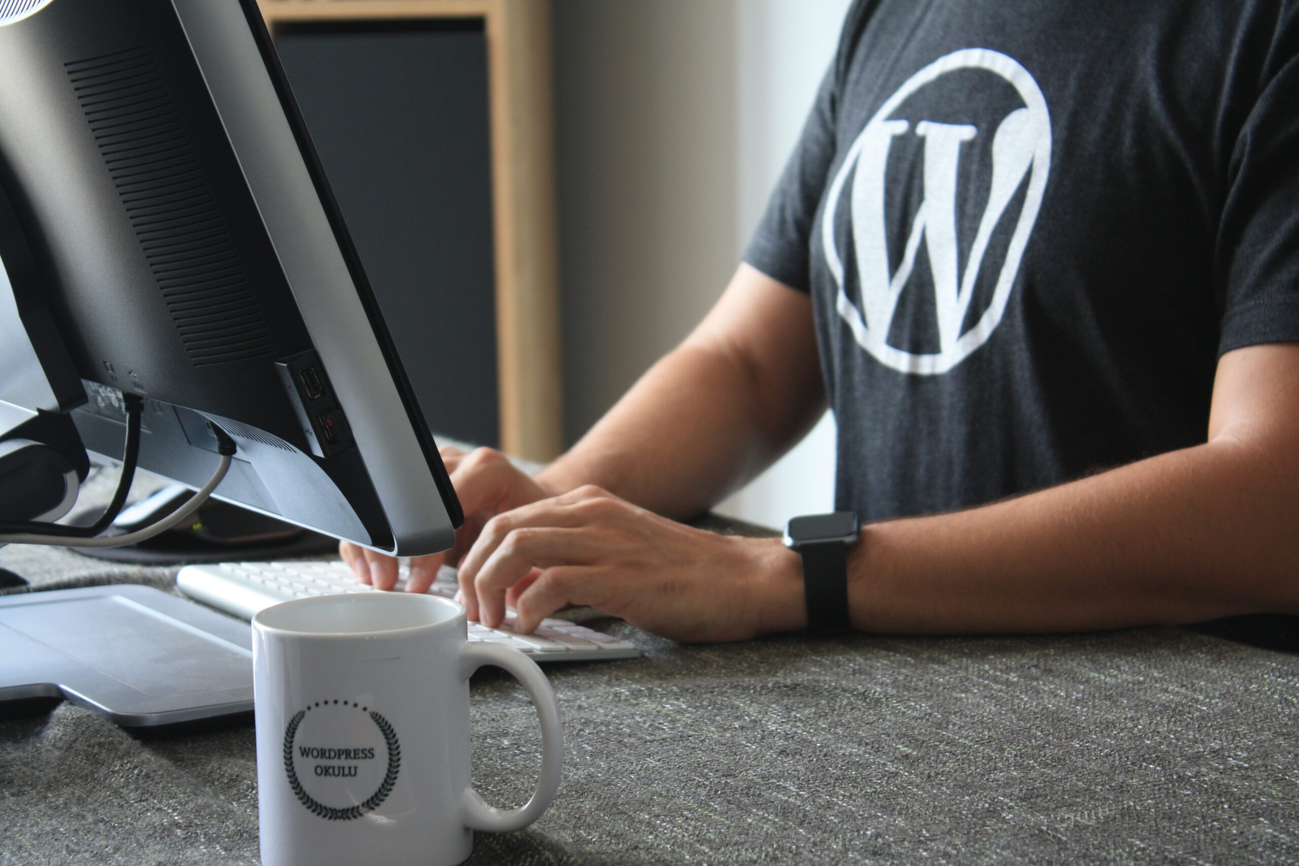 The Importance of Keeping Your WordPress and Plugins Updated 4 person in black and white t-shirt using computer